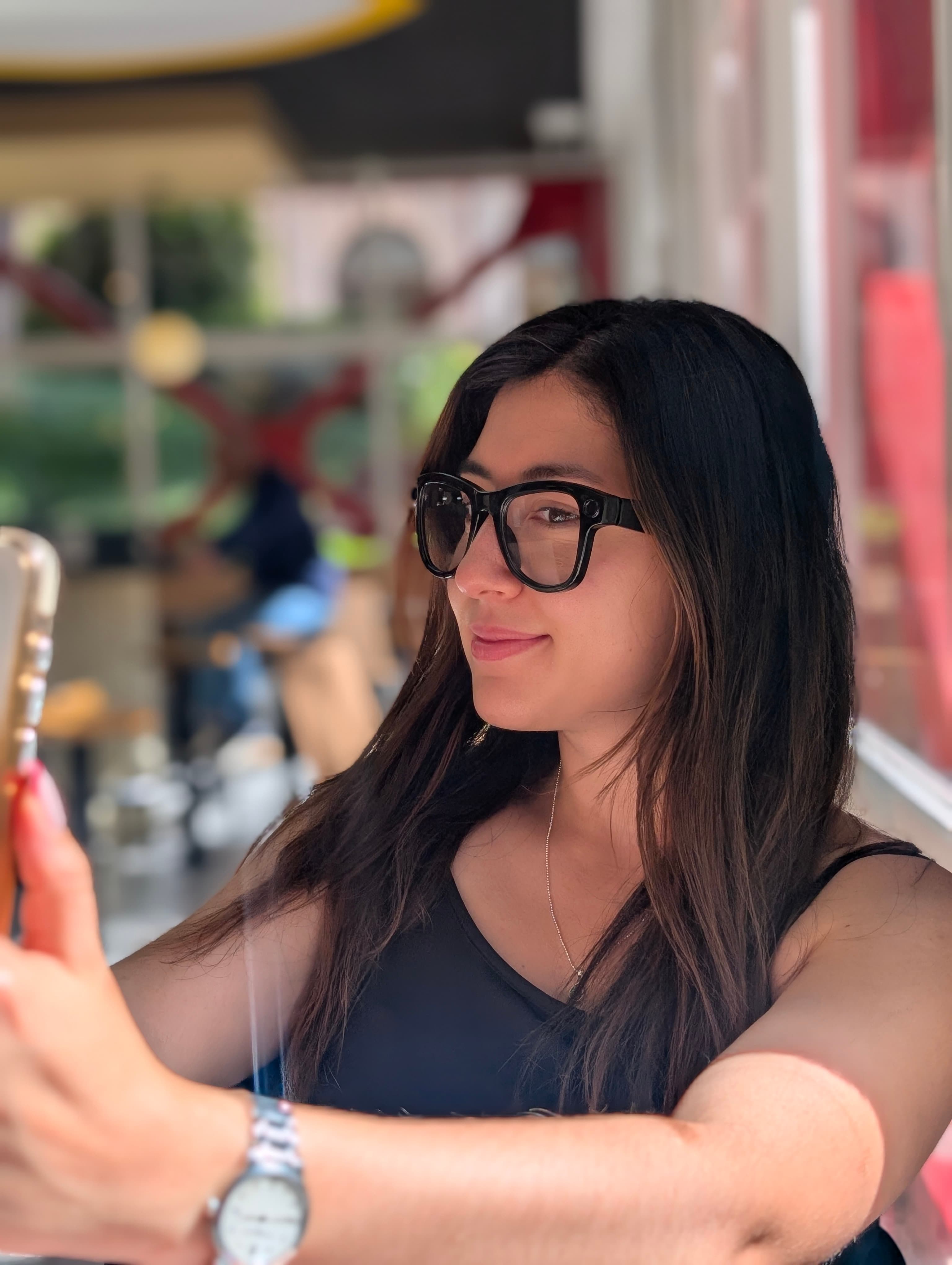 Mujer usando gafas AXIS de lente transparente en una cafetería